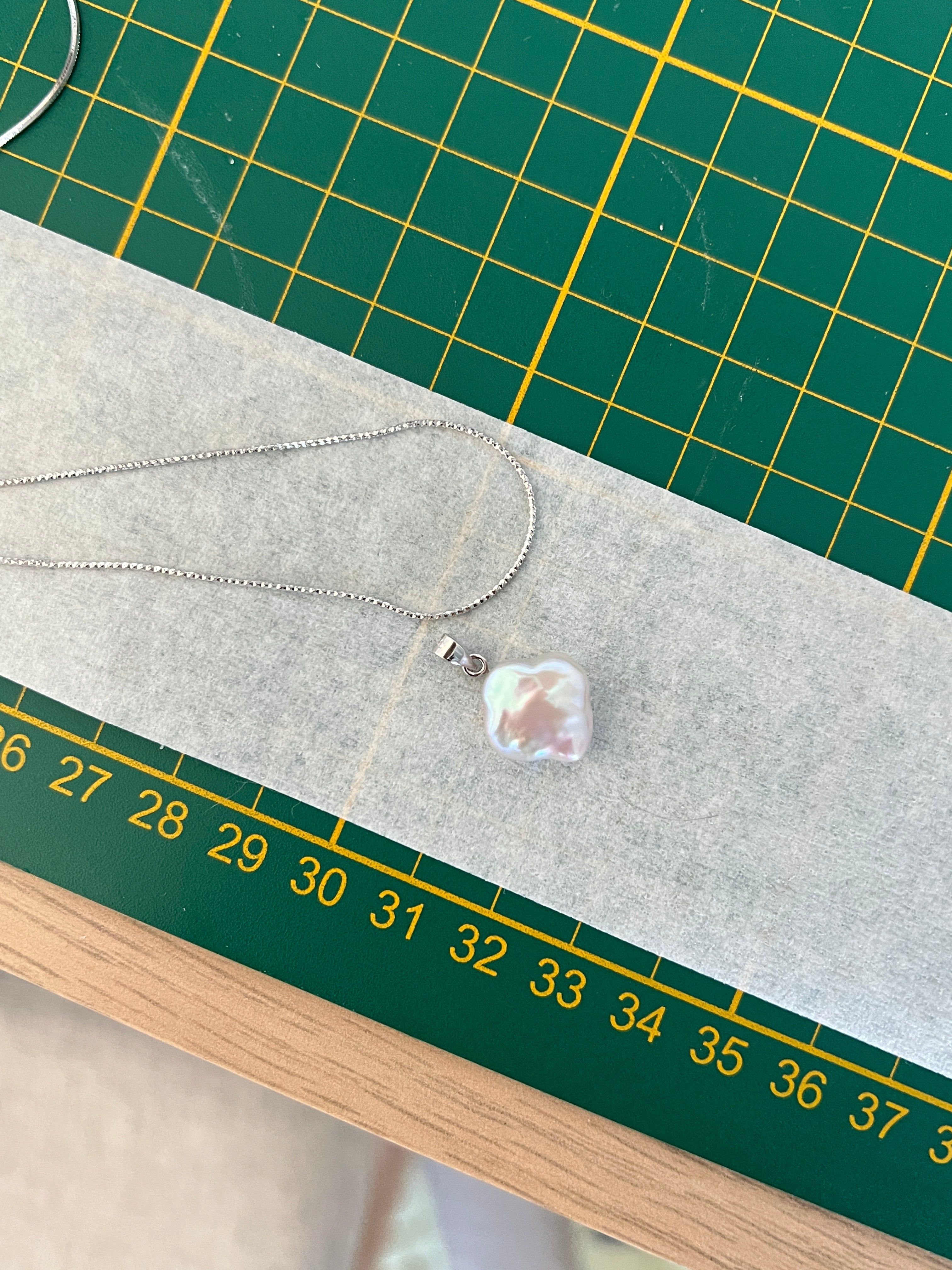 Adjustable length silver necklace with a natural white clover pearl pendant