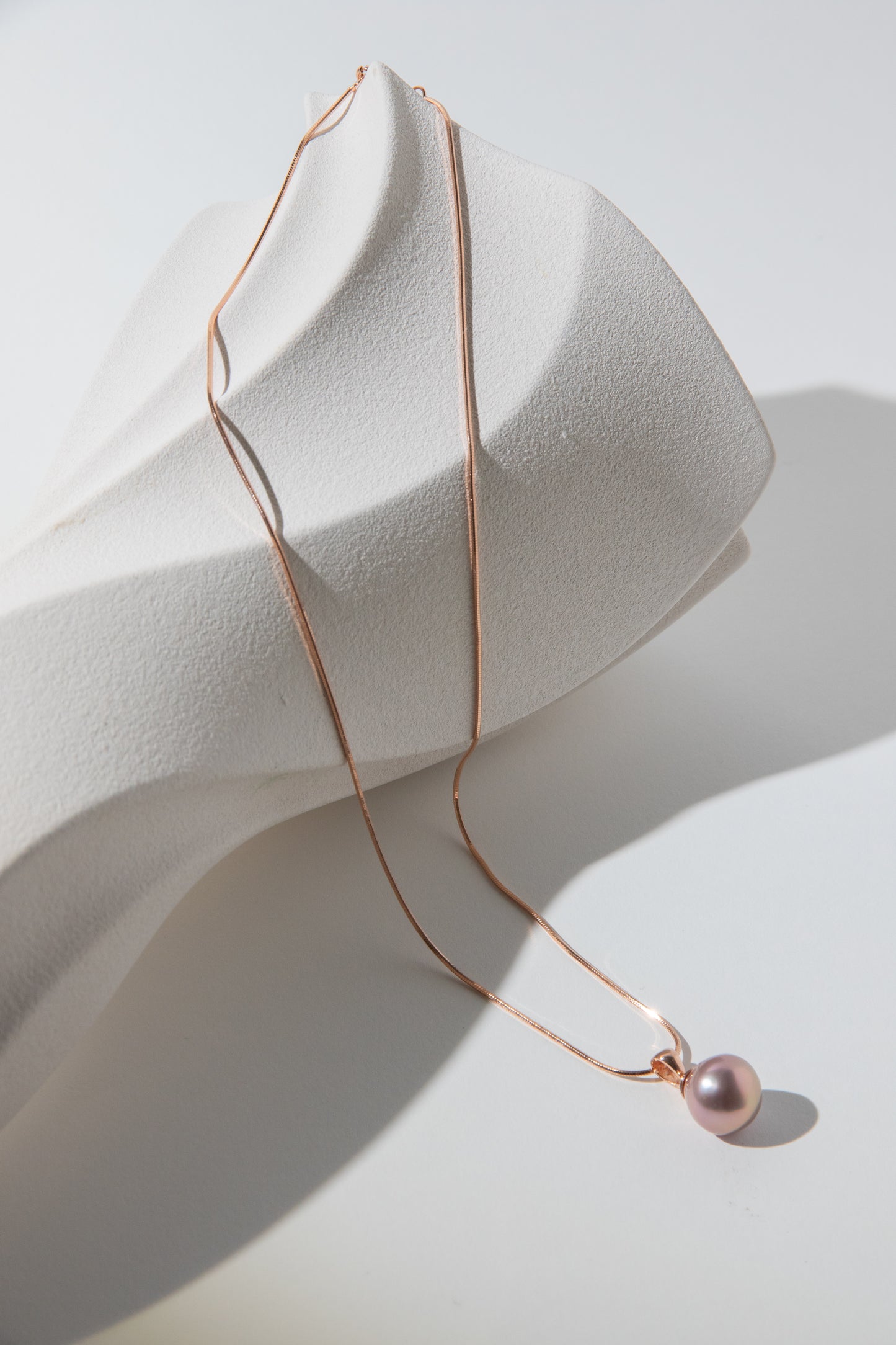 Metallic rosegold drop pearl necklace.