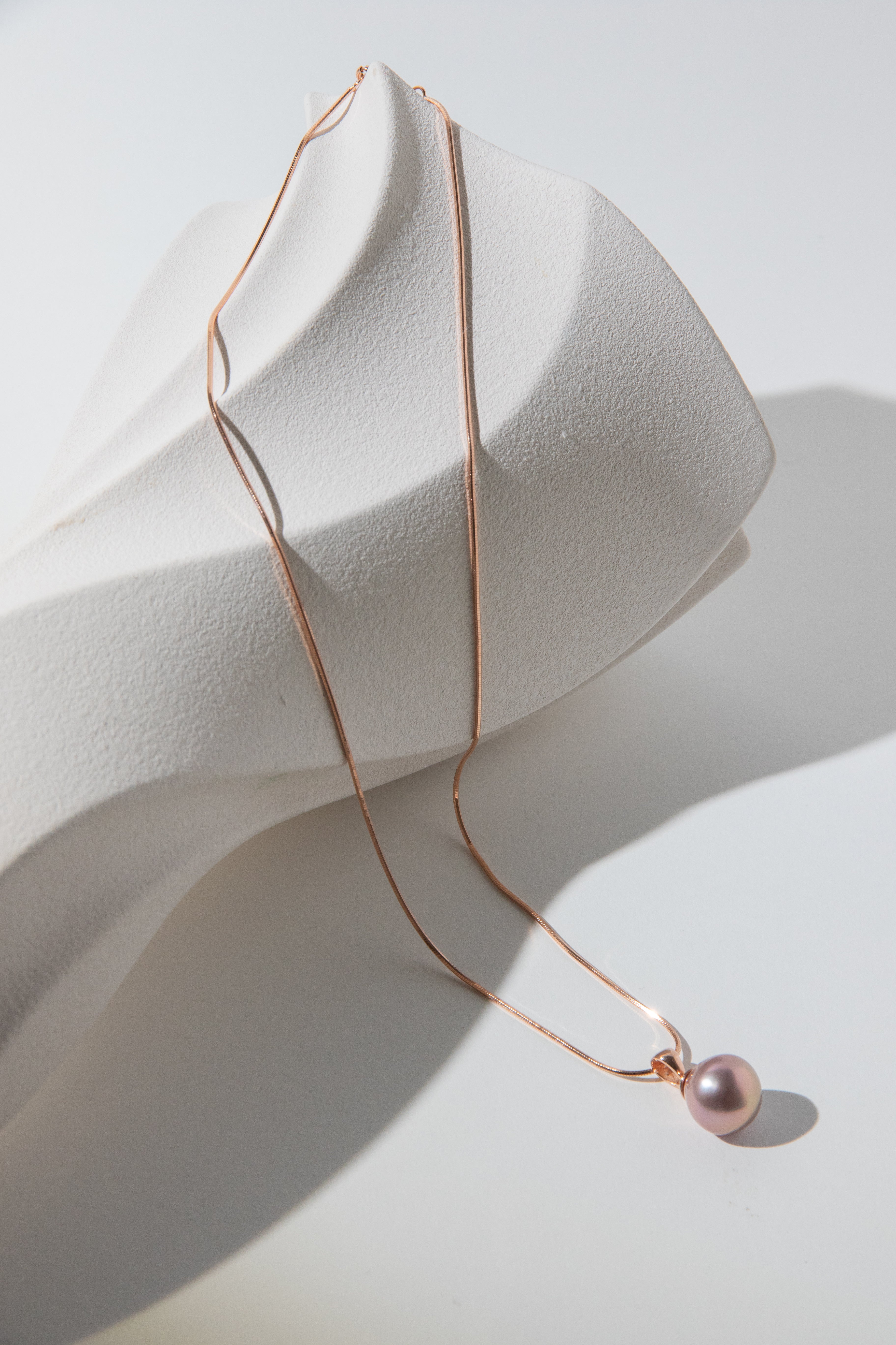 Metallic rosegold drop pearl necklace.