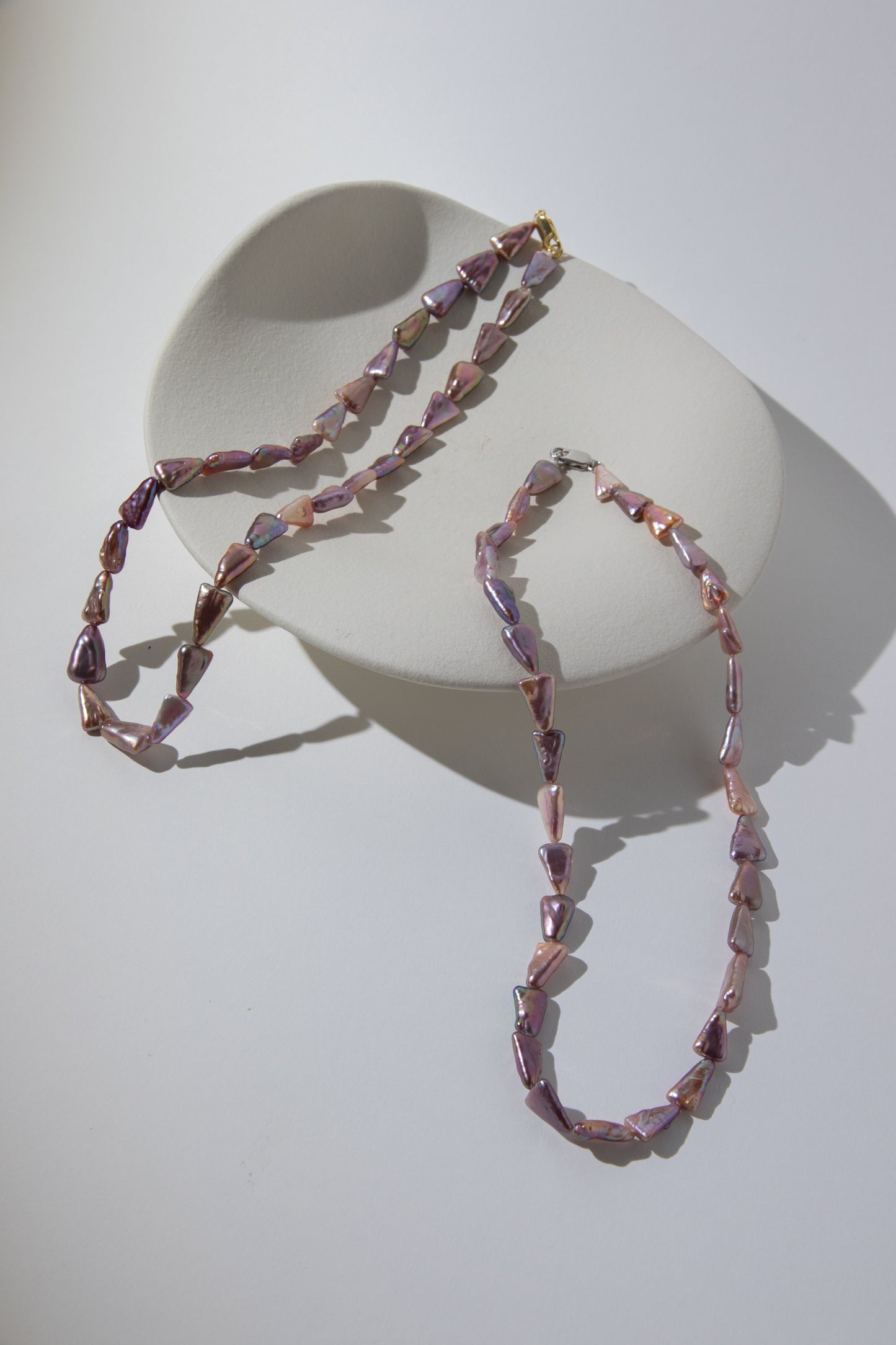 Direction pearl necklace-natural purple colored triangle pearls in silver/ gold plated silverclasps.