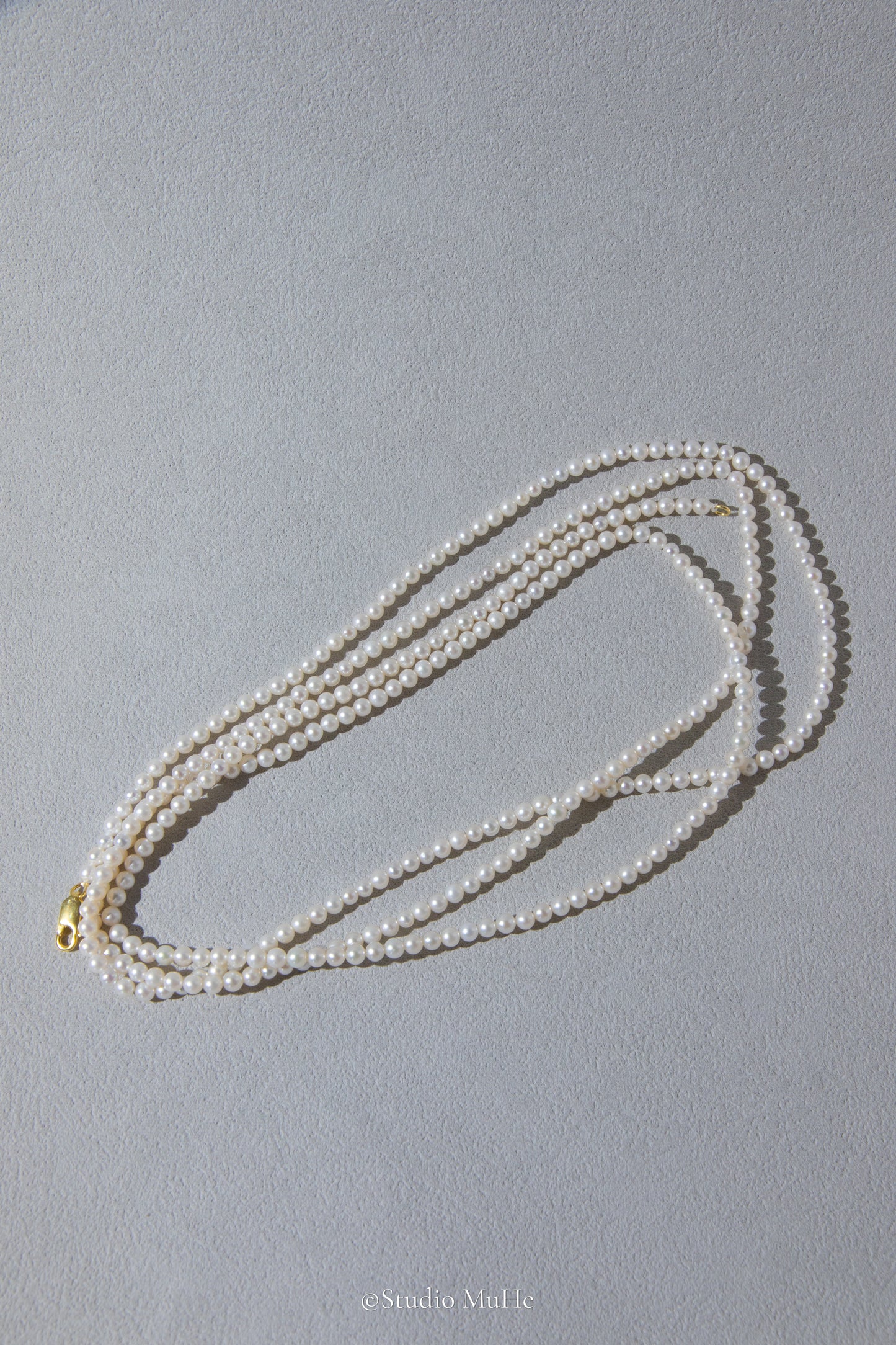 1.2 meters long necklace with small round white pearls.