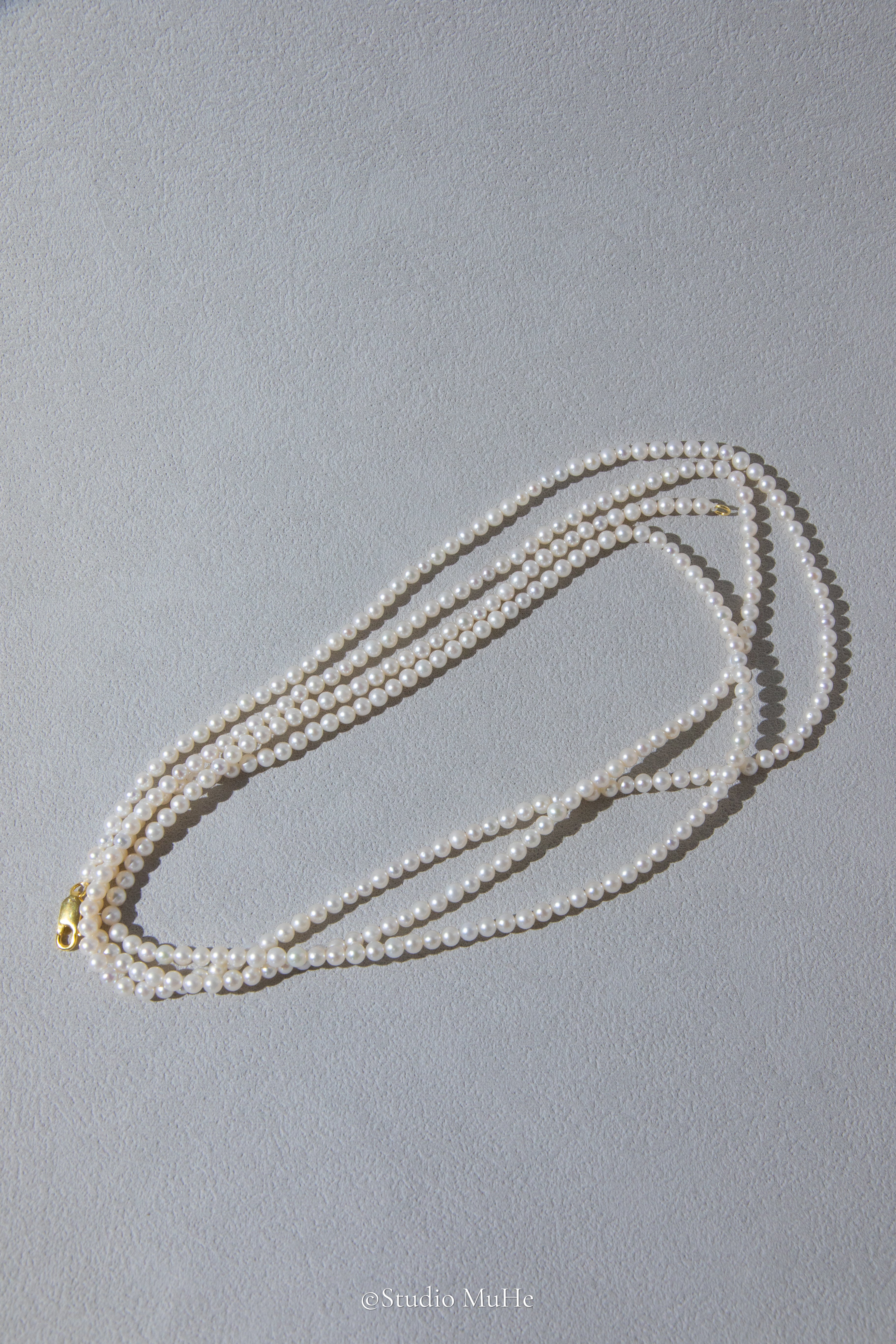 1.2 meters long necklace with small round white pearls.